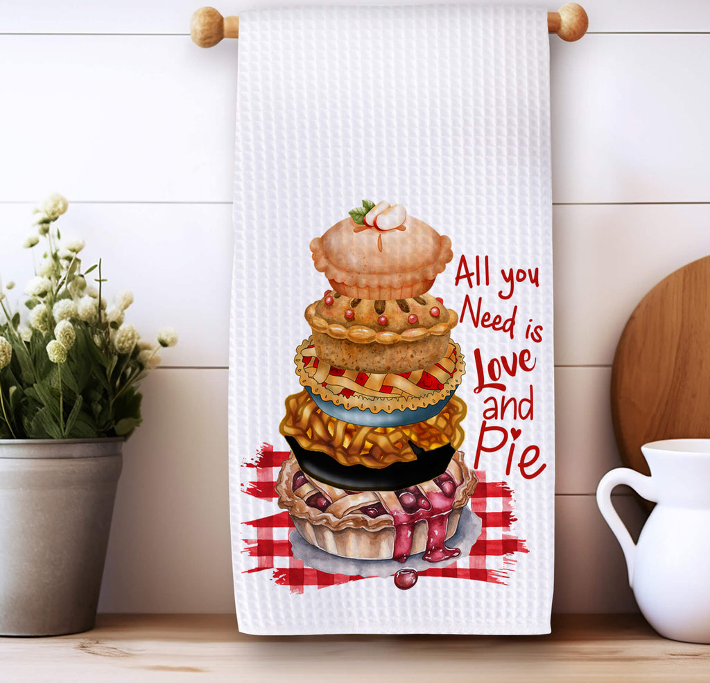 Funny baking kitchen towel featuring a stack of delicious pies, rustic gingham background, and the quote All You Need is Love and Pie Made from absorbent waffle weave fabric perfect for farmhouse kitchens, pie lovers, and rustic kitchen decor | Personalized Kreation