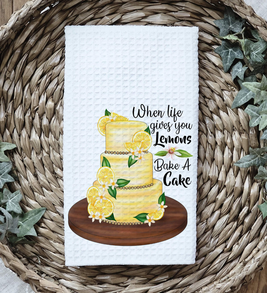 Lemon Cake Kitchen Towel - A beautifully designed white tea towel featuring a vibrant lemon-adorned cake with the phrase 'When Life Gives You Lemons, Bake A Cake.' Perfect for farmhouse decor, baking lovers, and unique kitchen gifts - Personalized Kreation