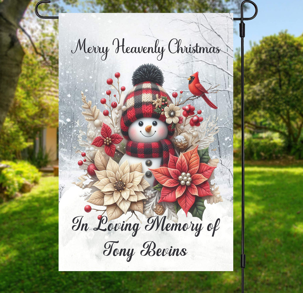 Garden flag with snowman, flowers, and cardinal bird design, featuring text 'Merry Heavenly Christmas In Loving Memory of Tony Bevins'.