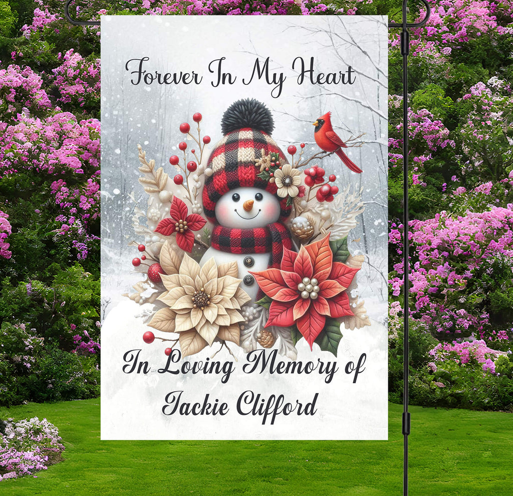 Memorial flag with snowman, flowers, and text 'Forever In My Heart In Loving Memory of Jackie Clifford' against a floral background.