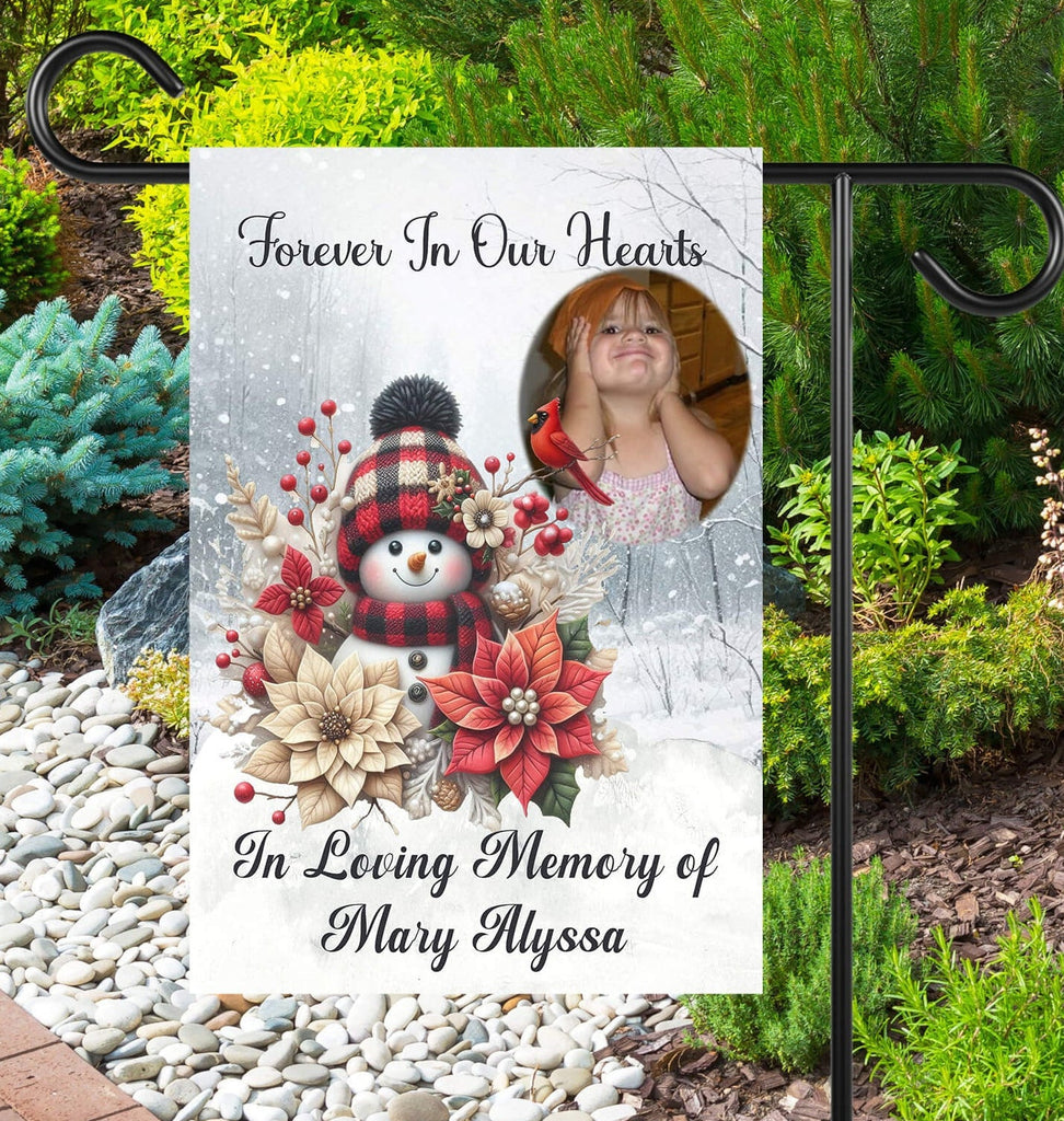 Memorial garden flag with snowman, flowers, and photo of a woman in a garden.