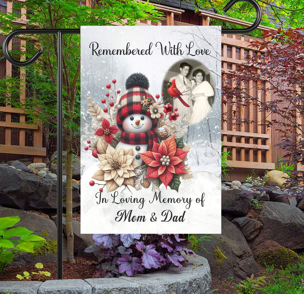 Memorial garden flag with snowman, flowers, and photo of a couple in a garden setting.