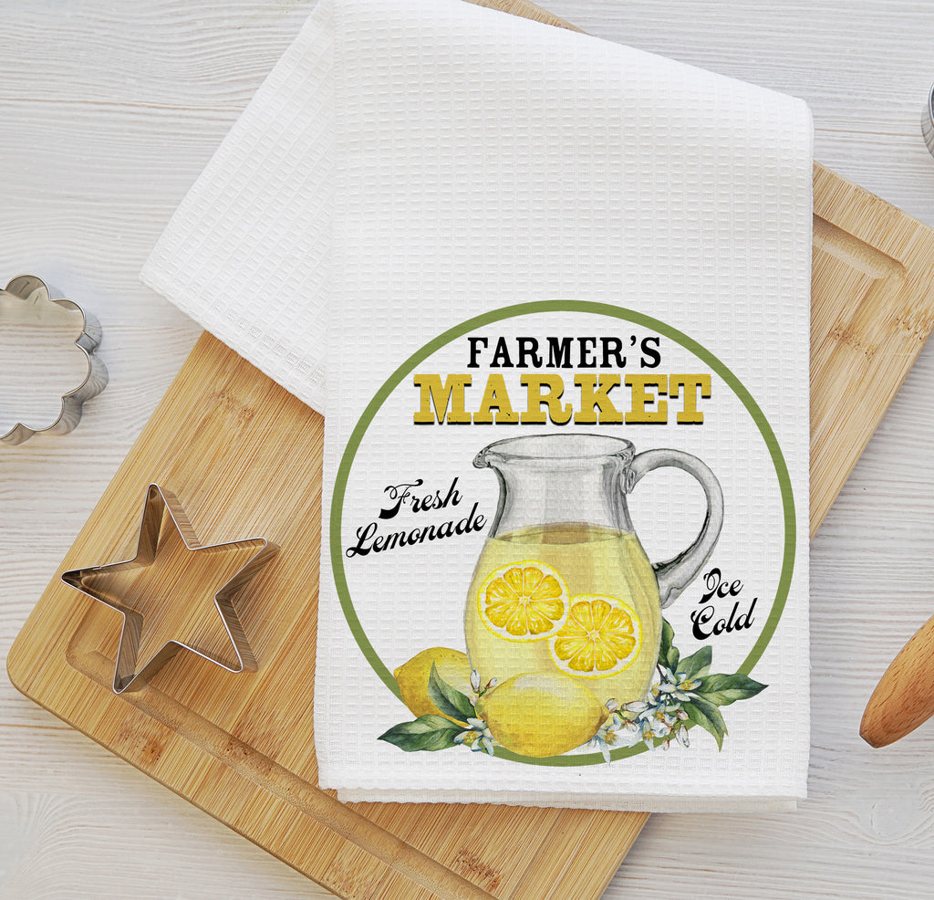 Farmhouse-style kitchen towel set featuring a vintage lemon market design. One towel showcases fresh lemons with 'Fruit Market' text, while the other displays a refreshing lemonade pitcher labeled 'Farmer’s Market.' Perfect for summer kitchen decor, farmhouse styling, and citrus-themed gifts - Personalized Kreation