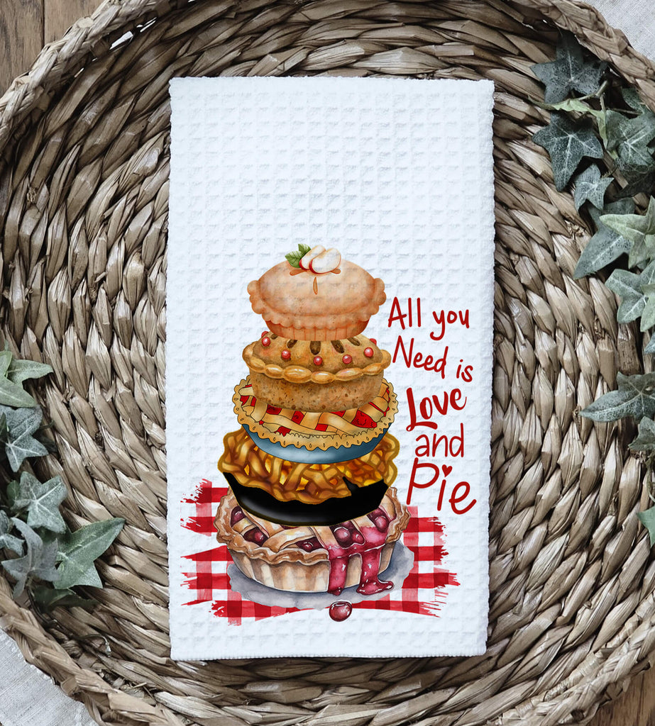 Funny baking kitchen towel featuring a stack of delicious pies, rustic gingham background, and the quote All You Need is Love and Pie Made from absorbent waffle weave fabric perfect for farmhouse kitchens, pie lovers, and rustic kitchen decor | Personalized Kreation