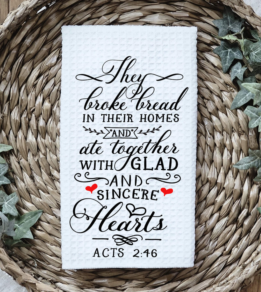 Christian kitchen towel featuring Acts 2:46 Bible verse, 'They broke bread in their homes and ate together with glad and sincere hearts.' Made from absorbent cotton, perfect for farmhouse kitchen décor, religious gifts, or inspirational home accents - Personalized Kreation