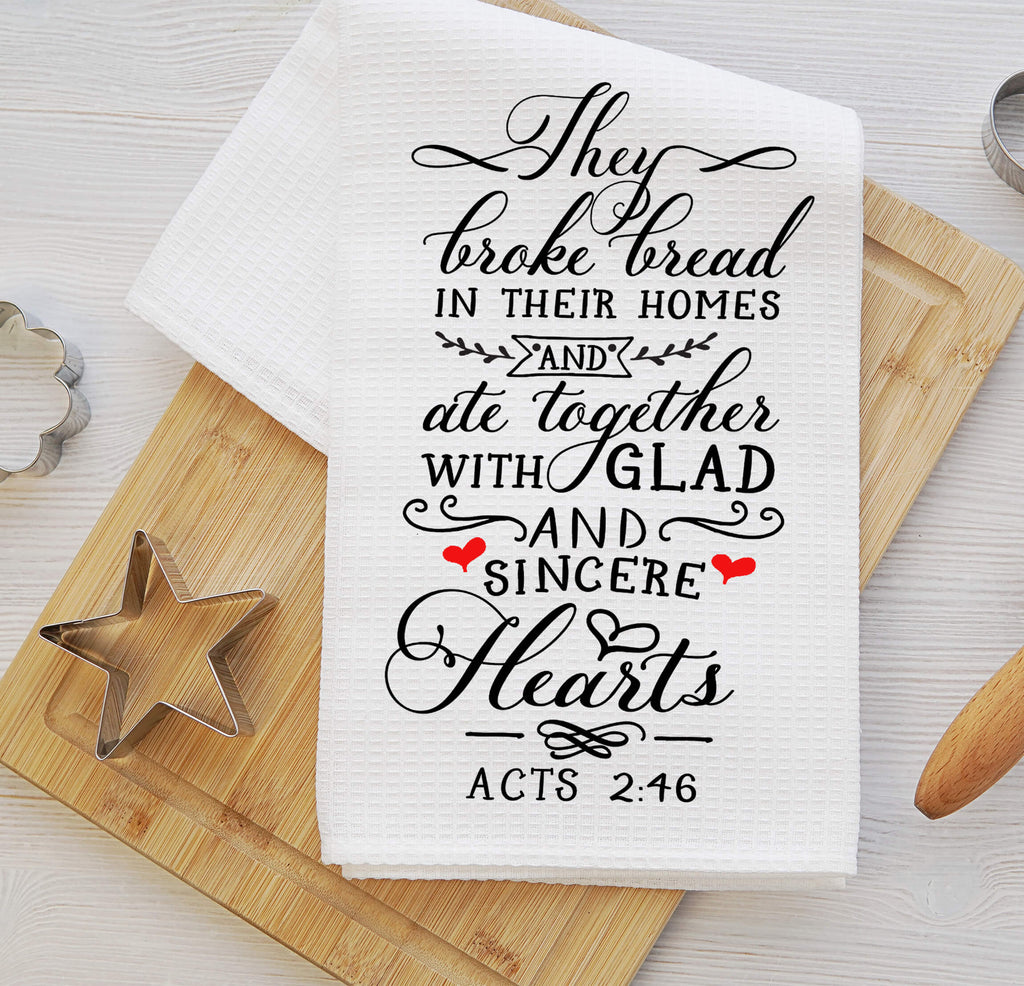 Christian kitchen towel featuring Acts 2:46 Bible verse, 'They broke bread in their homes and ate together with glad and sincere hearts.' Made from absorbent cotton, perfect for farmhouse kitchen décor, religious gifts, or inspirational home accents - Personalized Kreation