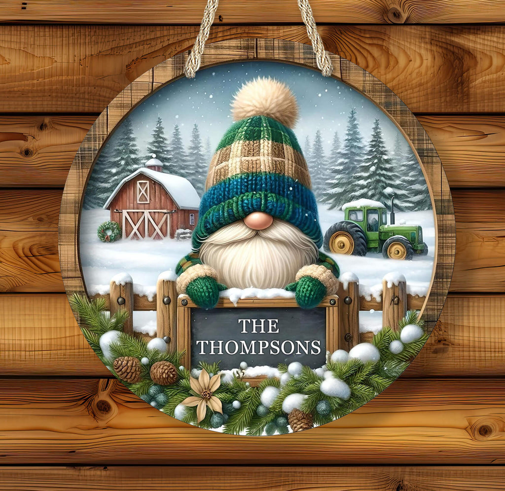 Decorative sign with a gnome, barn, and tractor in a snowy landscape on a wooden background.