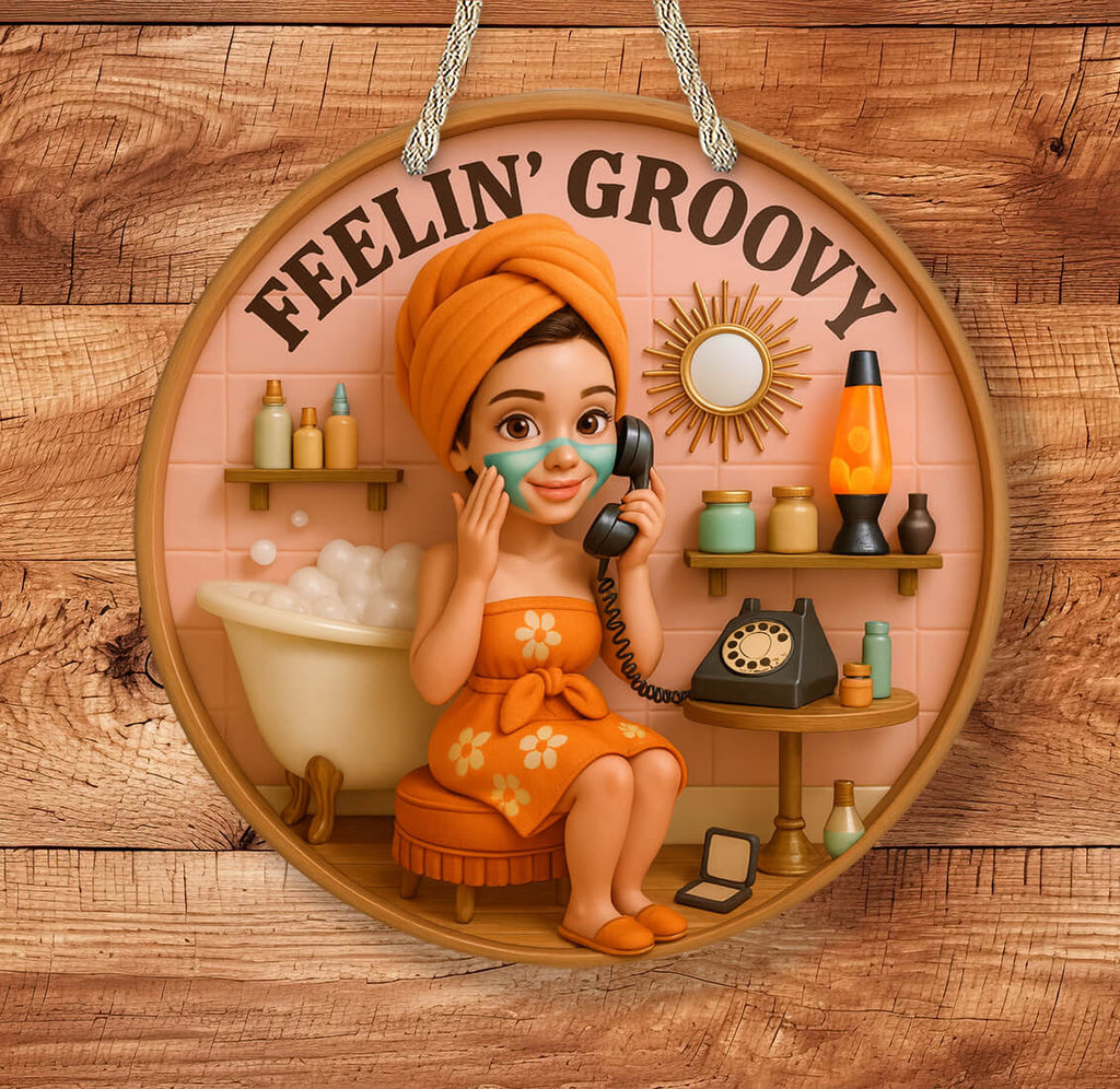 Decorative sign with a woman in an orange dress and towel, holding a phone, with 'Feelin' Groovy' text on a wooden background.
