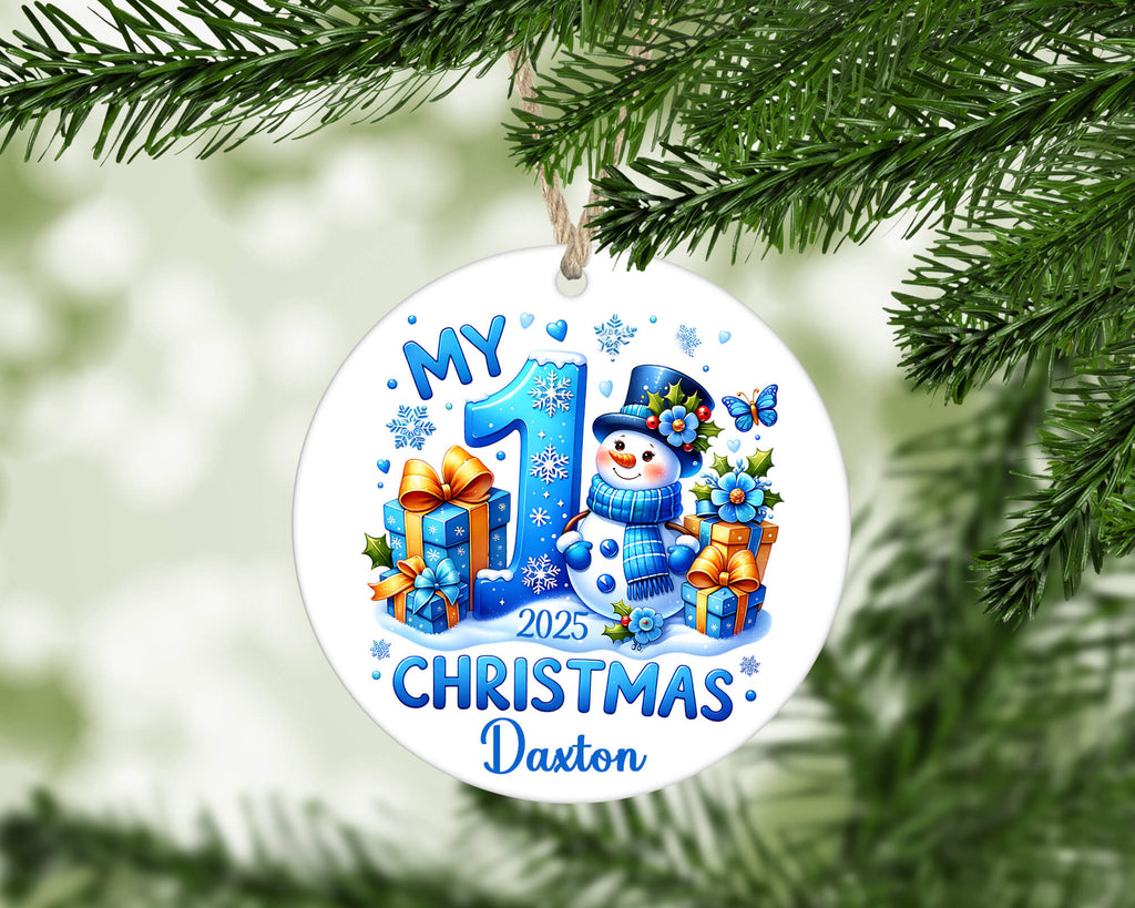 Christmas ornament with snowman and text 'My 1st Christmas 2025' on a green tree branch.