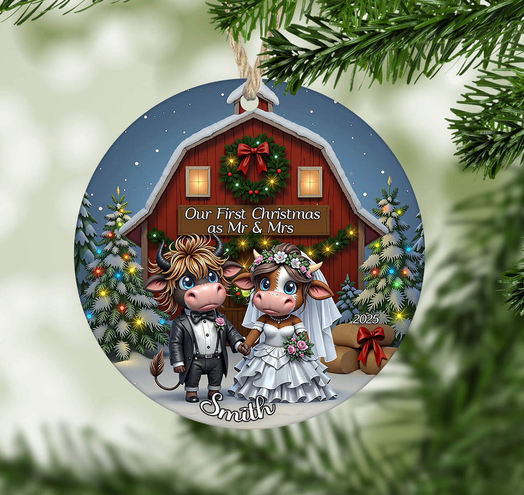 Decorative Christmas ornament with cartoon cow couple in front of a barn, surrounded by Christmas trees and lights.