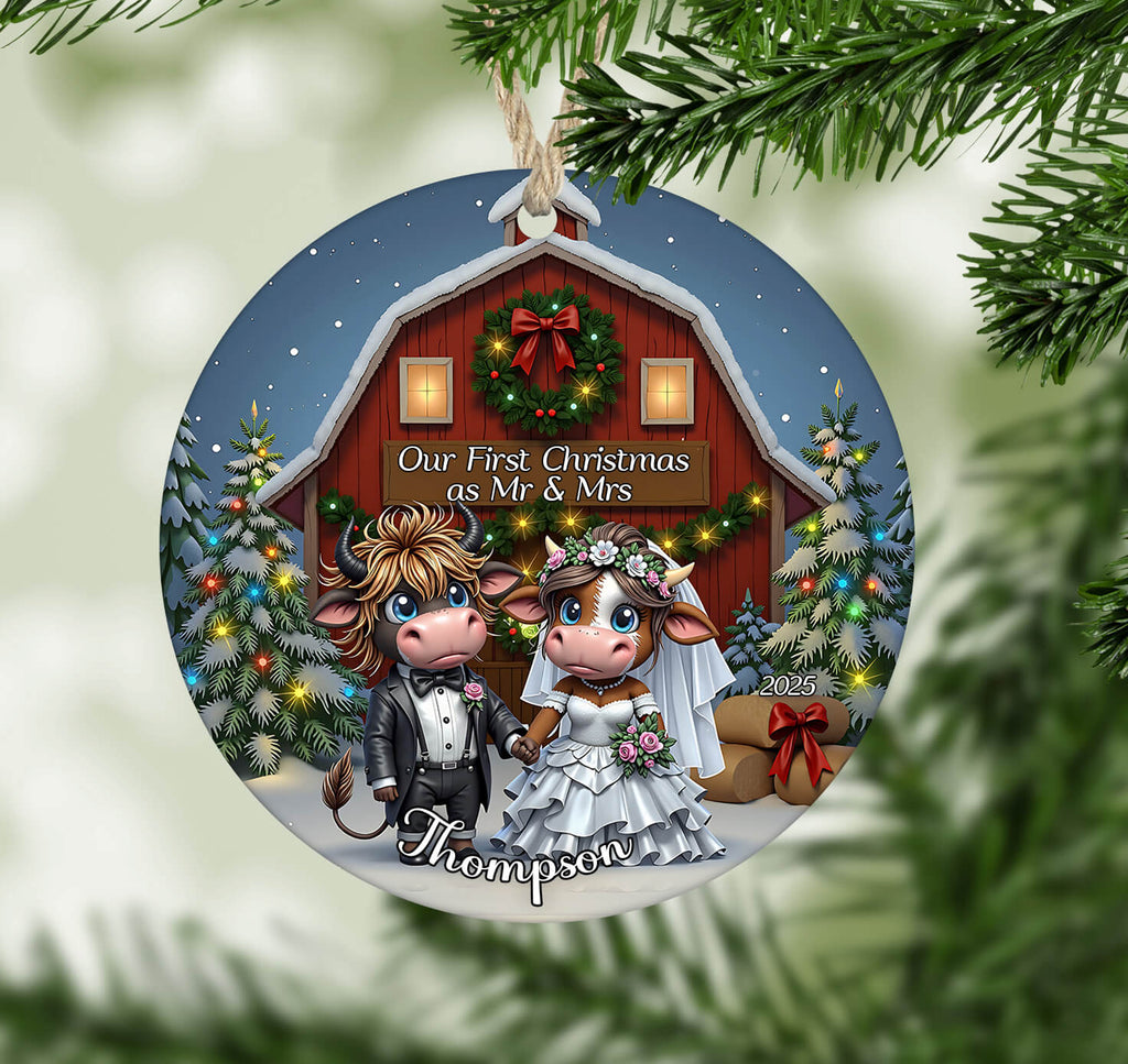 Decorative Christmas ornament with cartoon cows in wedding attire against a barn background.