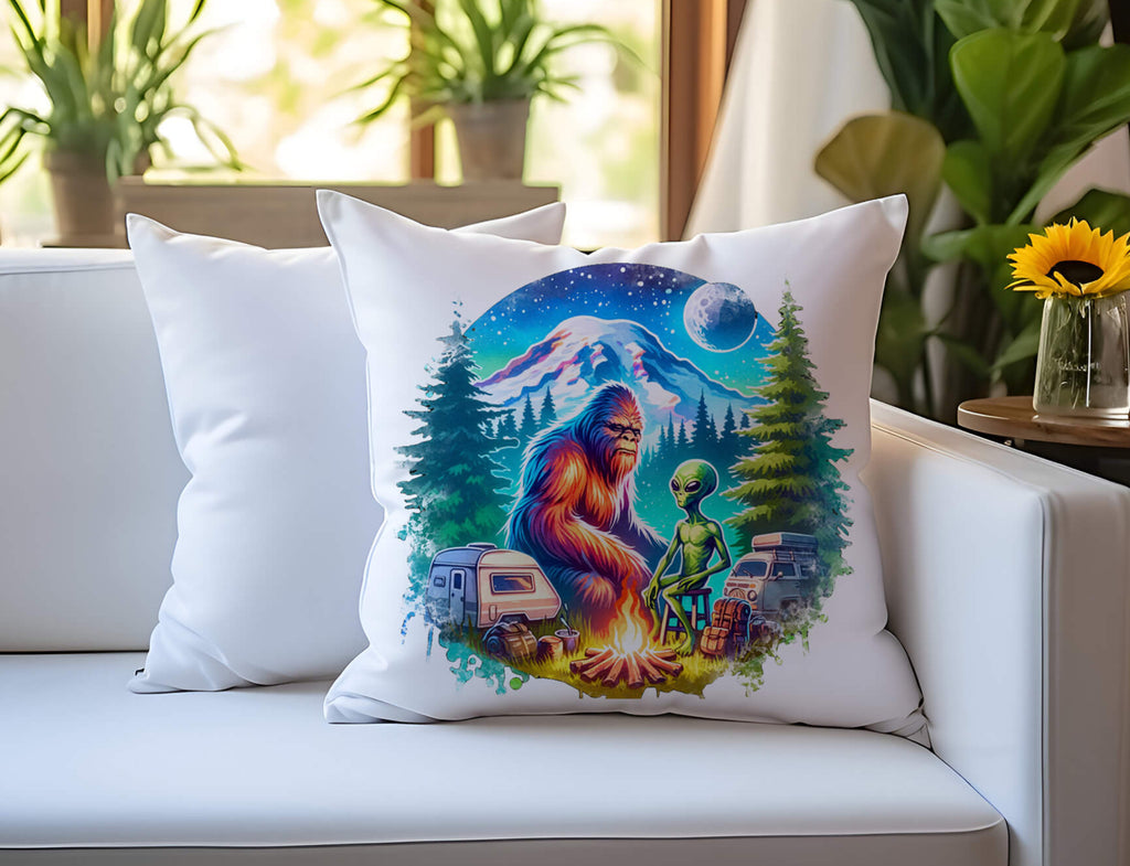 A funny Bigfoot and alien camping pillow featuring a retro-style design of Sasquatch and an alien roasting marshmallows by a campfire, surrounded by pine trees, under a cosmic starry sky with a glowing UFO in the background. The 18x18-inch pillow is available in white canvas  with a hidden zipper closure perfect for sci-fi lovers cryptid fans  and outdoor enthusiasts - Personakized Kreation