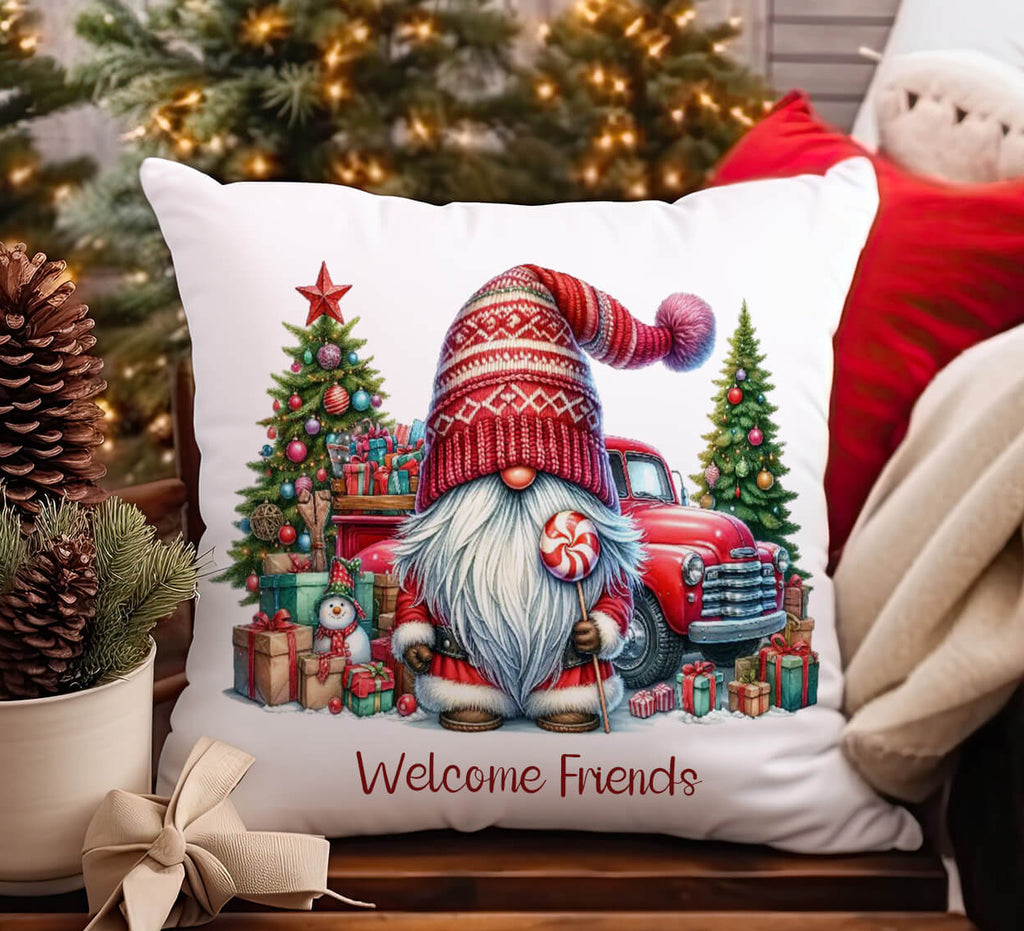Decorative pillow with a Christmas design featuring a gnome and truck, placed on a surface with festive decorations.