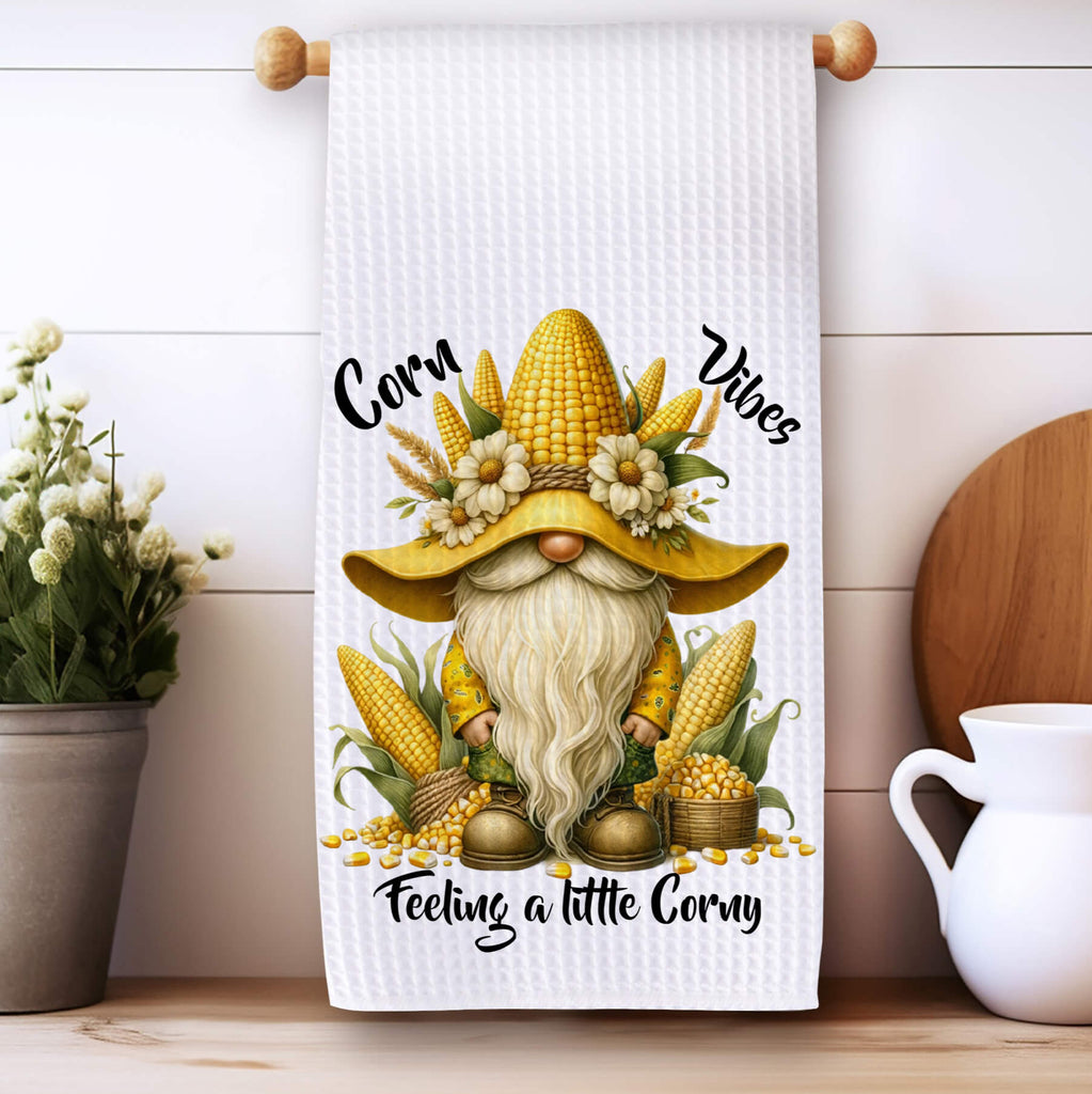 Rustic farmhouse kitchen towel featuring a whimsical corn gnome with harvest-themed decor, perfect for fall and Thanksgiving kitchen accents. Soft, absorbent, and machine washable, ideal for farmhouse kitchens and autumn decor lovers