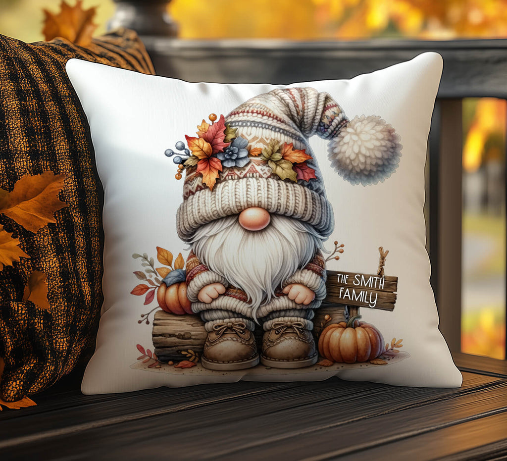 Decorative pillow with a gnome design featuring autumn elements on a wooden surface.