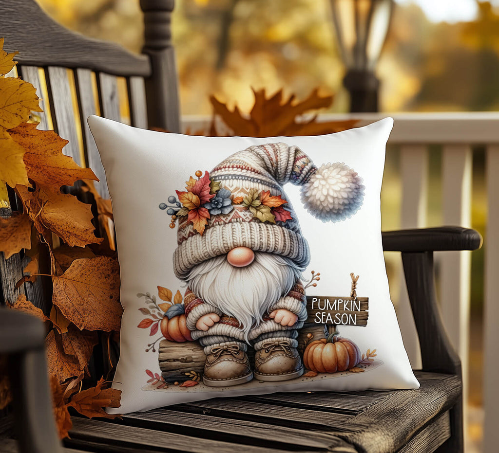 Decorative pillow with a gnome illustration and 'Pumpkin Season' text on a wooden chair outdoors.