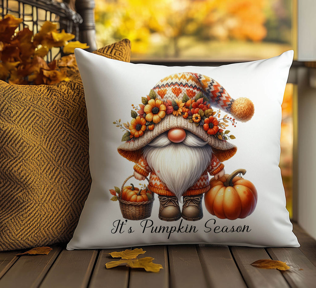 Decorative pillow with a gnome design and 'It's Pumpkin Season' text on a wooden surface.