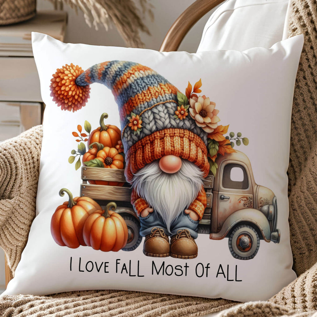 Decorative pillow with a gnome, pumpkins, and truck design on a chair.
