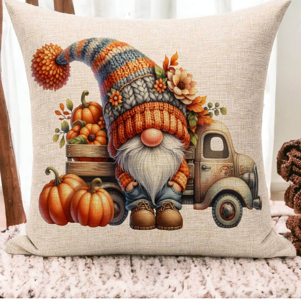 Decorative pillow with a gnome, pumpkins, and truck design on a neutral background.