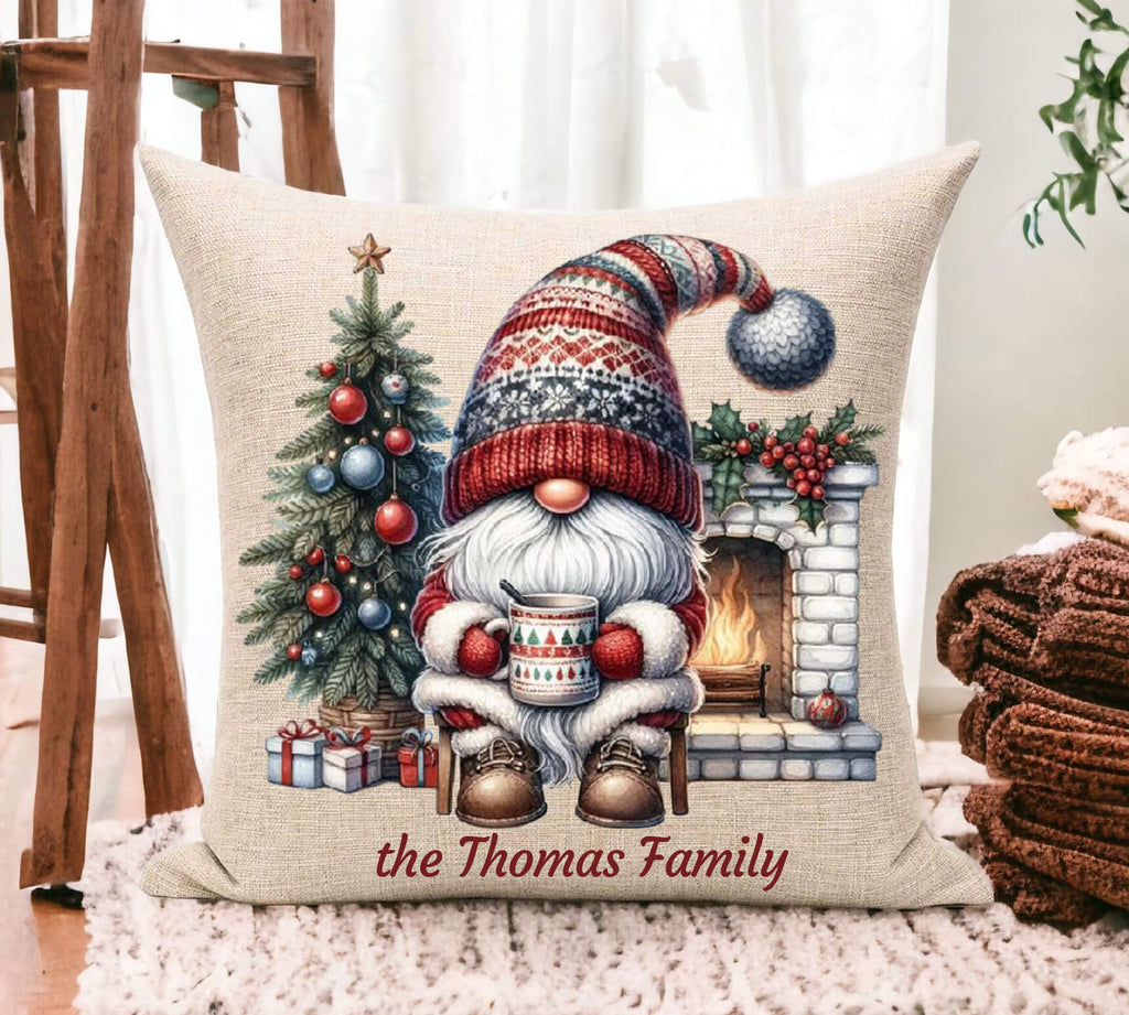Decorative pillow with a Christmas gnome design and 'the Thomas Family' text, placed on a surface.