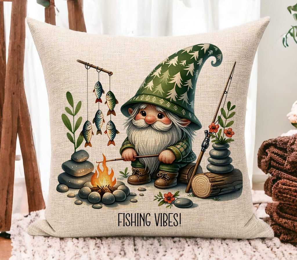 A personalized fishing gnome pillow featuring a gnome sitting by a campfire with fishing poles and fish. The pillow is 18x18 inches, available in white canvas or beige linen, with a hidden zipper closure. Ideal for fishing lovers, rustic cabin decor, or camping enthusiasts. Perfect for adding a touch of the great outdoors to any space - Personalized Kreation