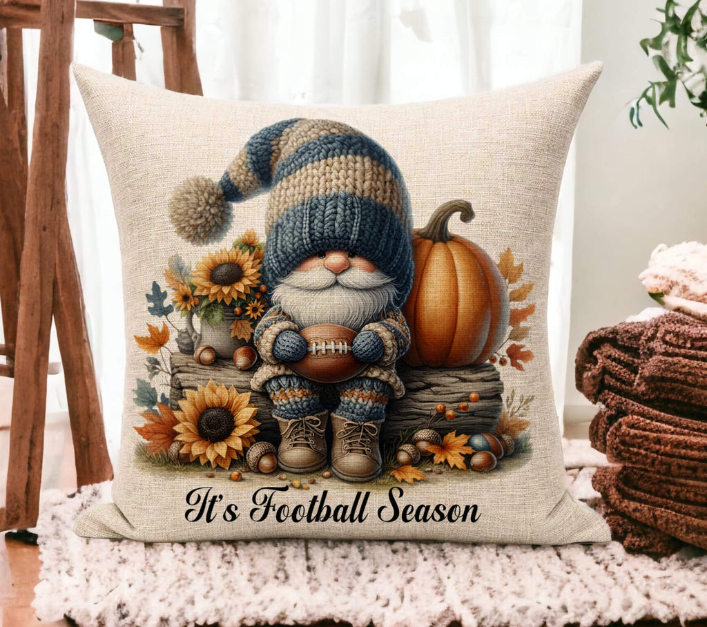 Decorative pillow with a gnome and autumn elements on a wooden floor.