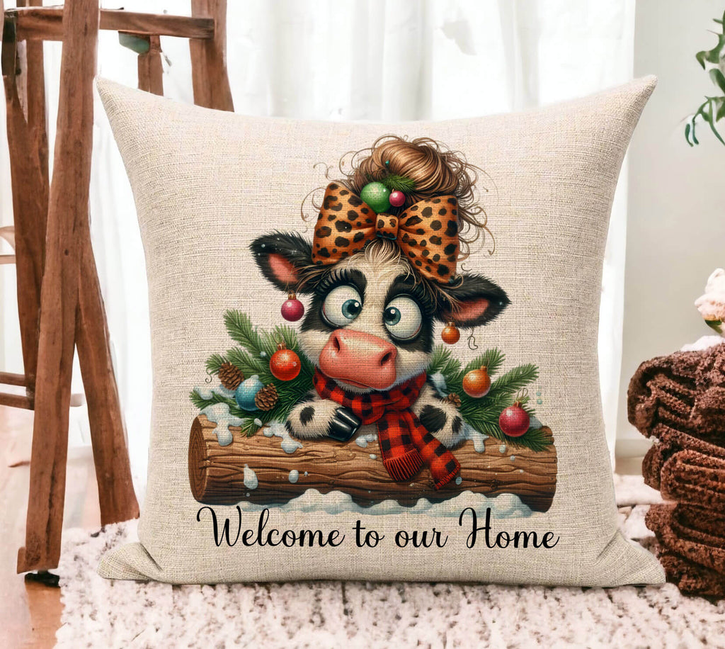 Decorative pillow with a cow illustration and Christmas elements on a beige background.