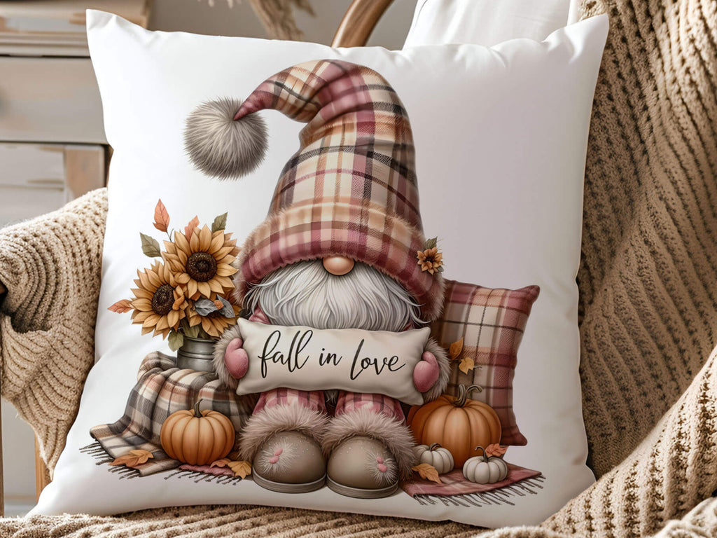 Decorative pillow with a gnome holding a 'fall in love' sign, surrounded by pumpkins and sunflowers, on a textured surface.