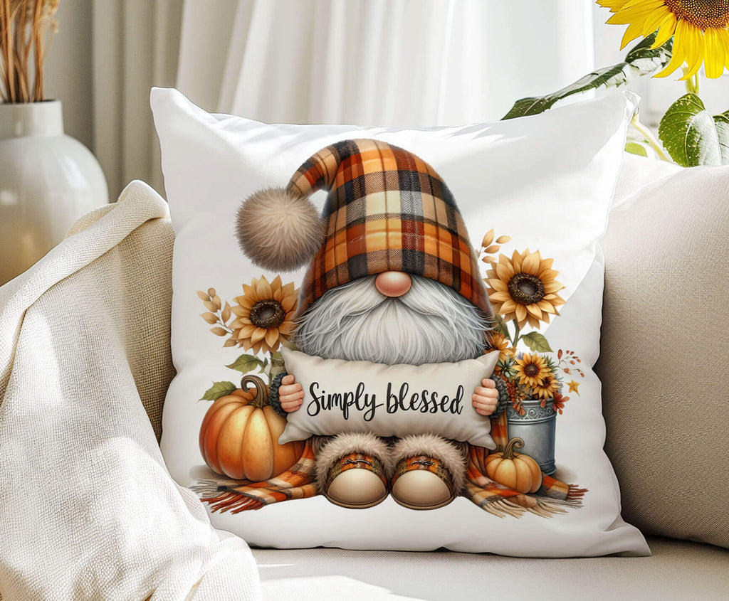 Decorative pillow with a gnome holding a 'Simply blessed' sign, surrounded by autumn elements on a couch.