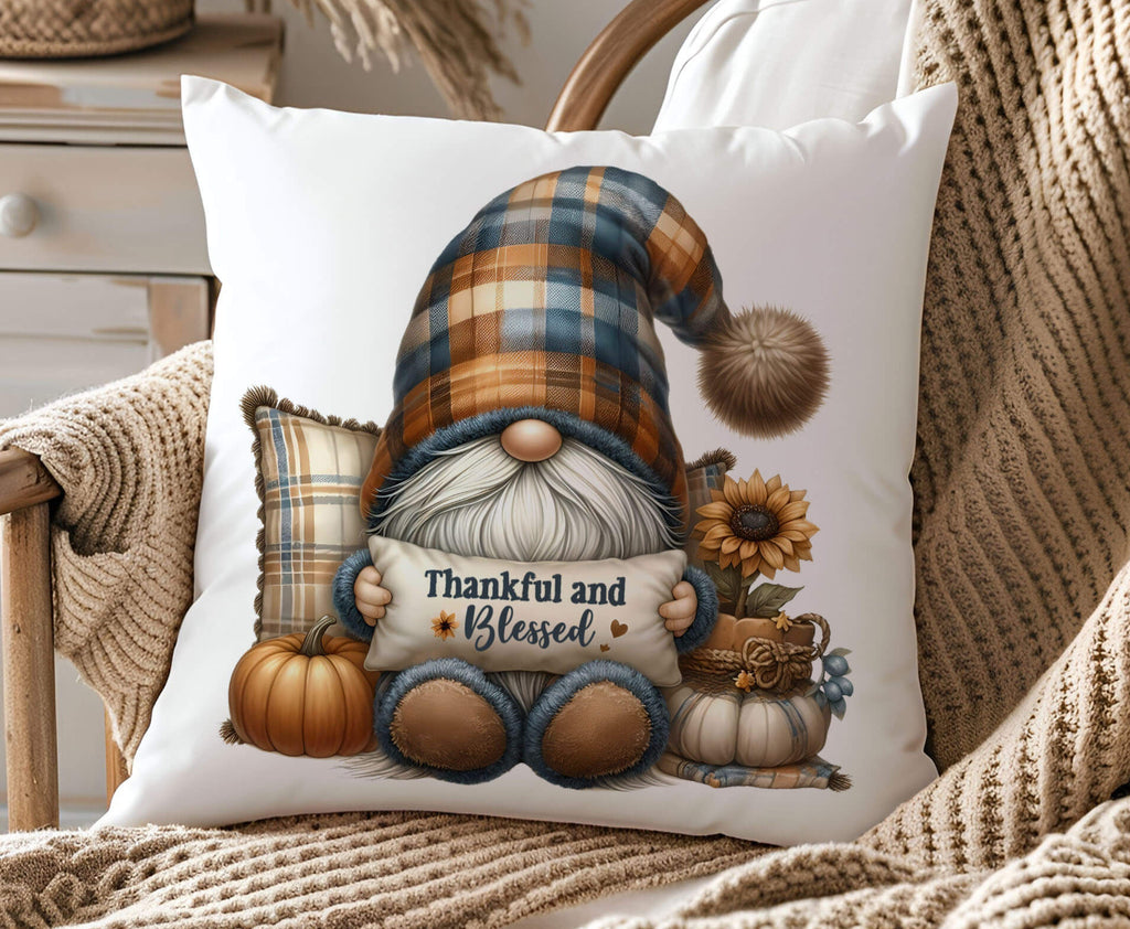 Decorative pillow with a gnome holding a 'Thankful and Blessed' sign, surrounded by pumpkins and sunflowers, on a cozy chair.