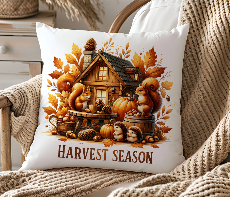 Decorative pillow with 'Harvest Season' design featuring pumpkins, squirrels, and a cabin on a couch.
