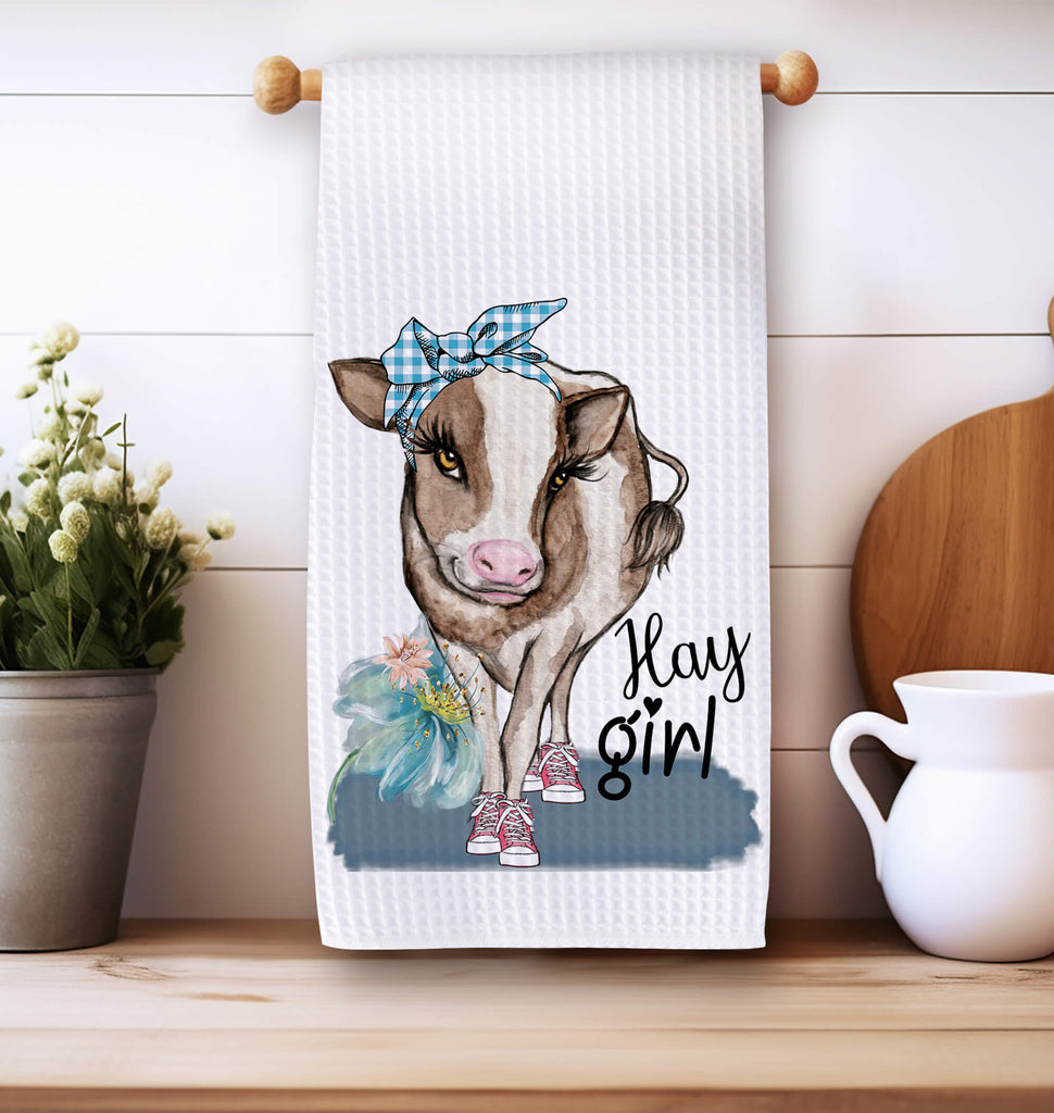 Farmhouse cow kitchen towel featuring a cute cow wearing a blue bandana and sneakers with "Hay Girl" text, perfect for rustic country decor and farmhouse kitchen style. Made from high-quality absorbent fabric, ideal for drying dishes or decorative use - Personalized Kreation