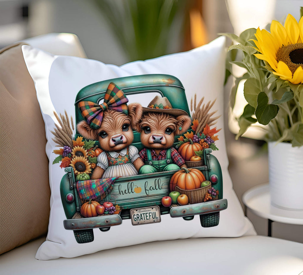 Decorative pillow with highland cows in a truck and fall-themed design on a surface.
