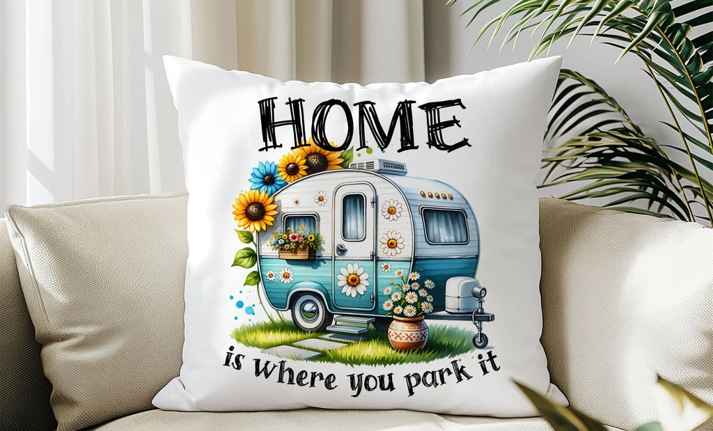 18x18 inch Linen-style camper pillow with teal retro trailer, sunflowers, daisies, and quote “Home is where you park it,” styled in cozy indoor setting - Personalized Kreation