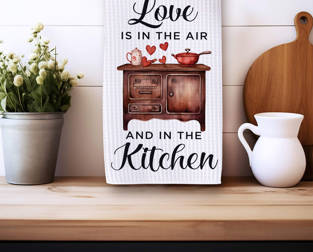 Love Is in the Air kitchen towel with a vintage stove, hearts, and farmhouse design. Rustic Valentine’s dish towel, perfect for romantic kitchen decor, housewarming gift, or gift for her. Soft, absorbent, machine washable, and stylish for any home