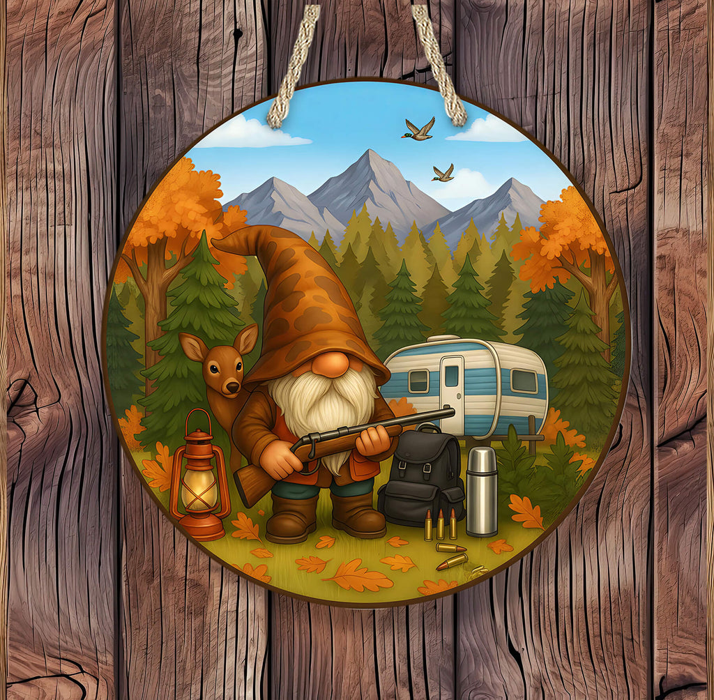 Decorative plate with a gnome, deer, and camper in a forest scene, hanging on a wooden background.