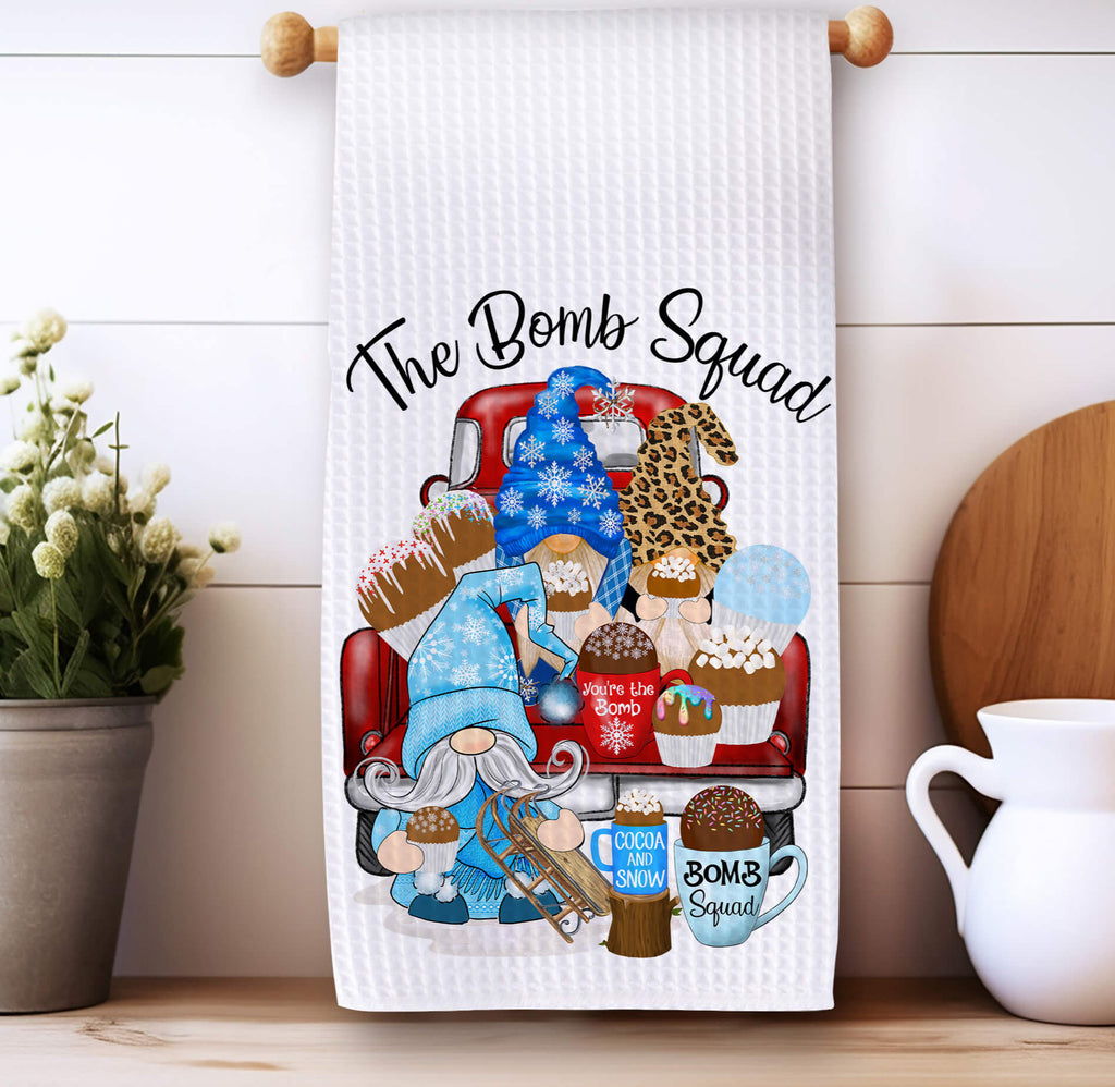 Hot Cocoa Bomb Squad kitchen towel featuring winter gnomes, hot chocolate bombs, and festive holiday decor. Made from absorbent waffle weave fabric, perfect for Christmas baking, farmhouse kitchens, and cozy winter decorations - Personalized Kreation