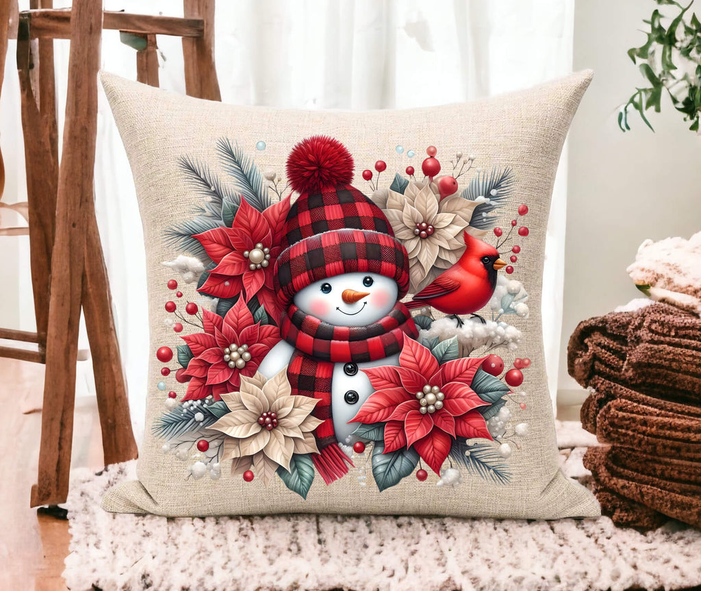 Decorative pillow with Christmas-themed design featuring a snowman, cardinal, and poinsettias.