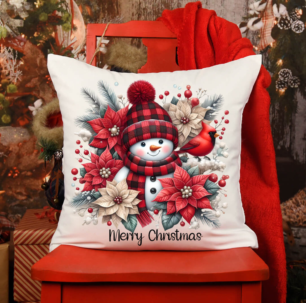 Christmas-themed pillow with snowman design on a red chair.