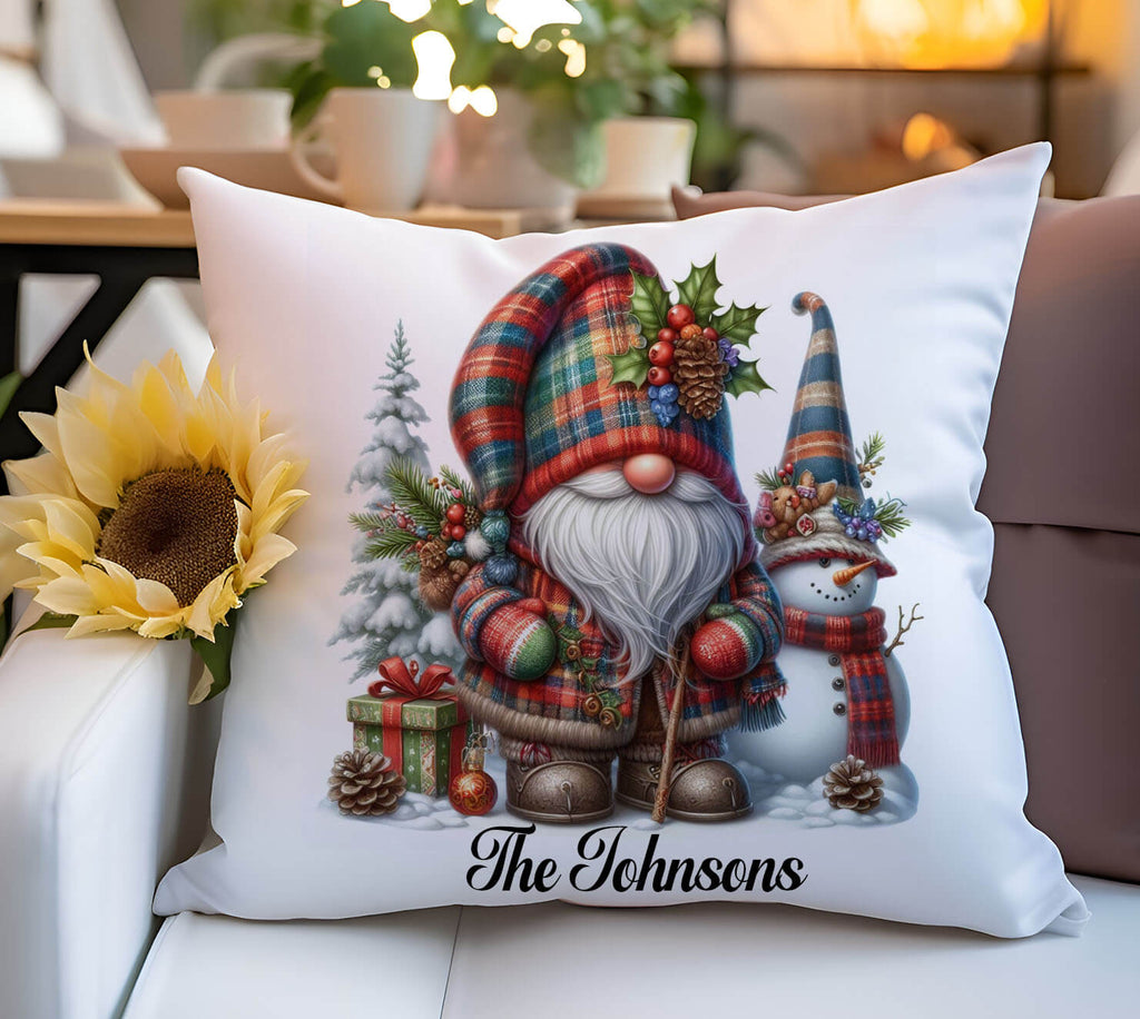 Decorative pillow with Christmas-themed design featuring a gnome and snowman, placed on a couch.