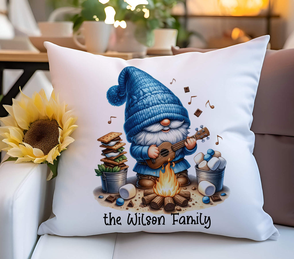 A personalized camping pillow featuring a cute gnome playing a guitar by a campfire, surrounded by marshmallows, chocolate, and s’mores ingredients. Available in 18x18 inches, white canvas or beige linen, with a hidden zipper closure. Perfect for camping lovers, rustic home decor, and cozy cabin retreats - Peronalized Kreation