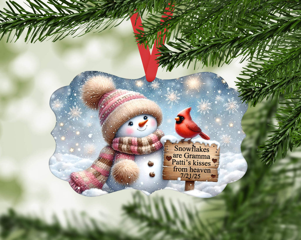 Christmas ornament with snowman and cardinal on a snowy background, hanging from a tree.