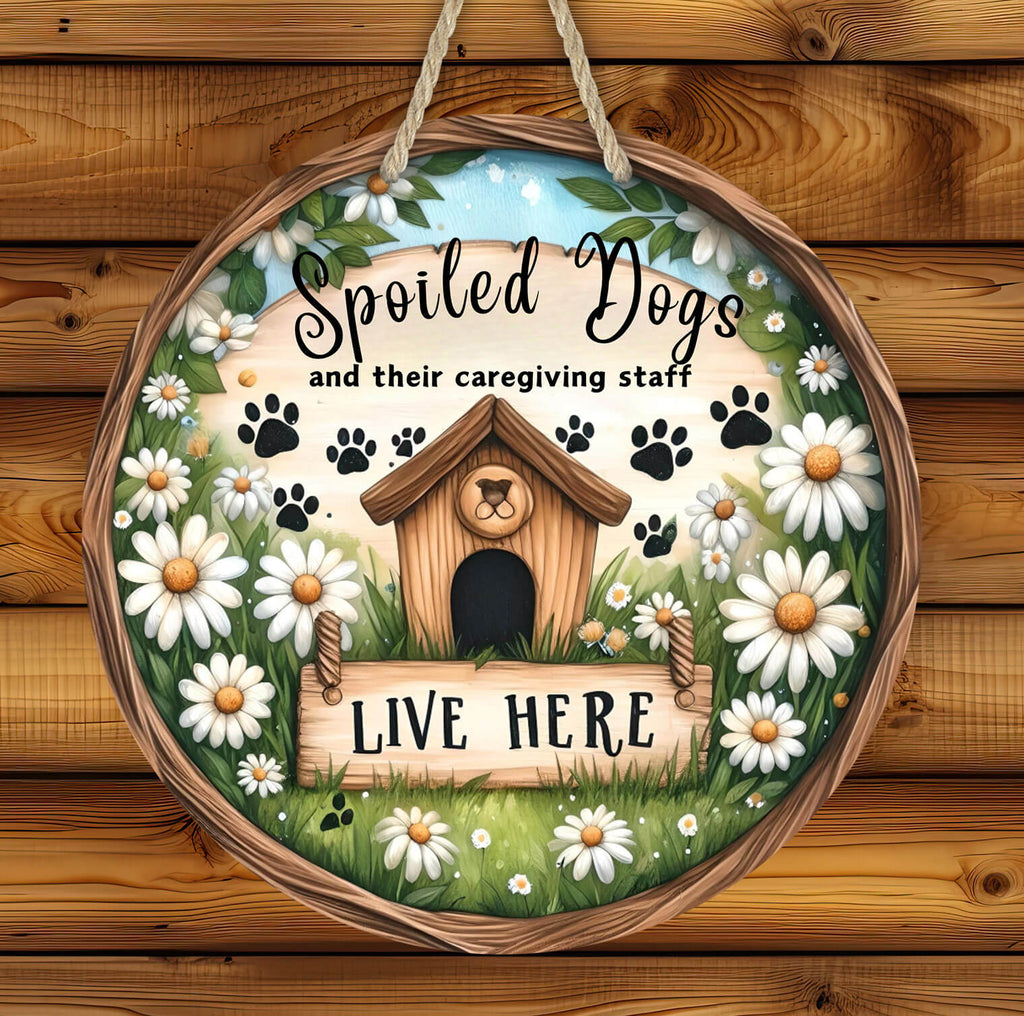 rustic hardboard 14 inch round dog sign featuring a cozy doghouse, paw prints, and white daisies with the phrase "Spoiled Dogs and Their Caregiving Staff Live Here," designed for pet lovers, farmhouse decor, and dog-friendly homes - Personalized Kreation