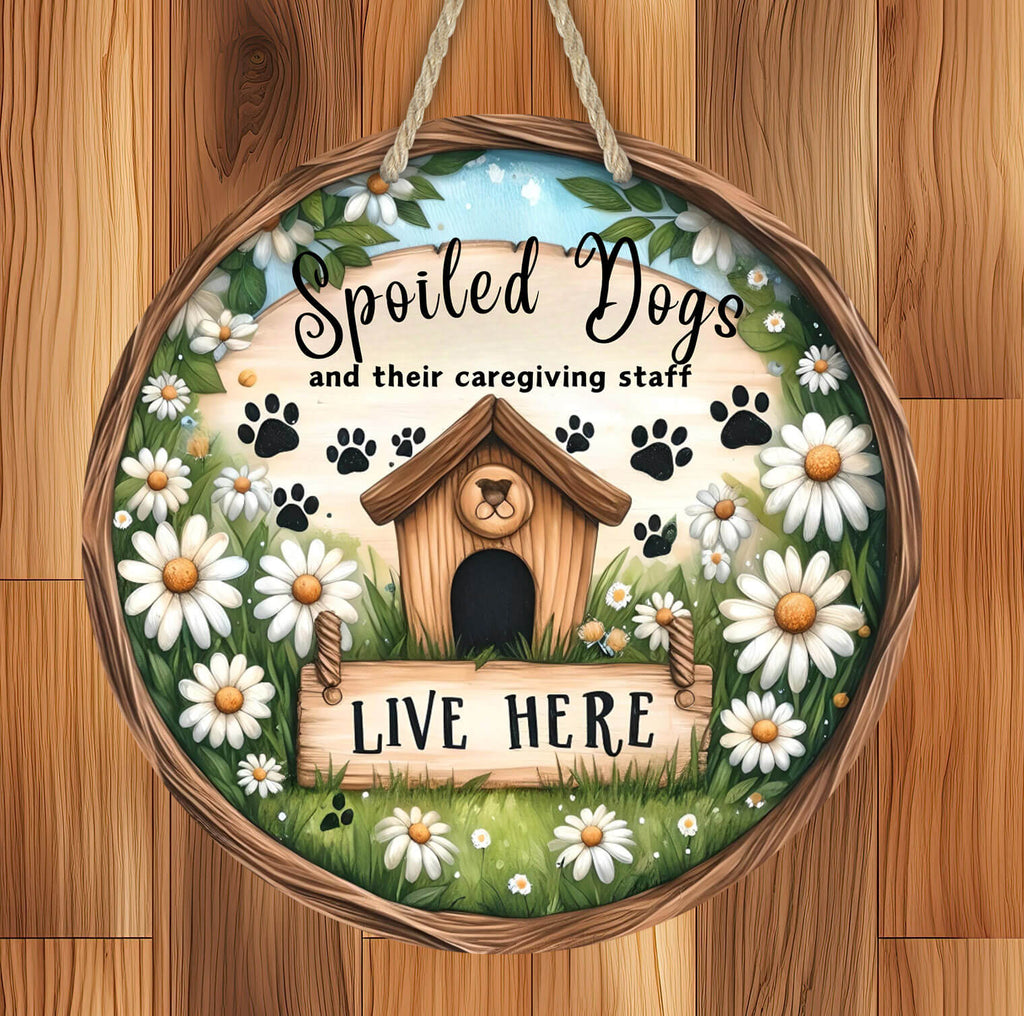 rustic hardboard 14 inch round dog sign featuring a cozy doghouse, paw prints, and white daisies with the phrase "Spoiled Dogs and Their Caregiving Staff Live Here," designed for pet lovers, farmhouse decor, and dog-friendly homes - Personalized Kreation