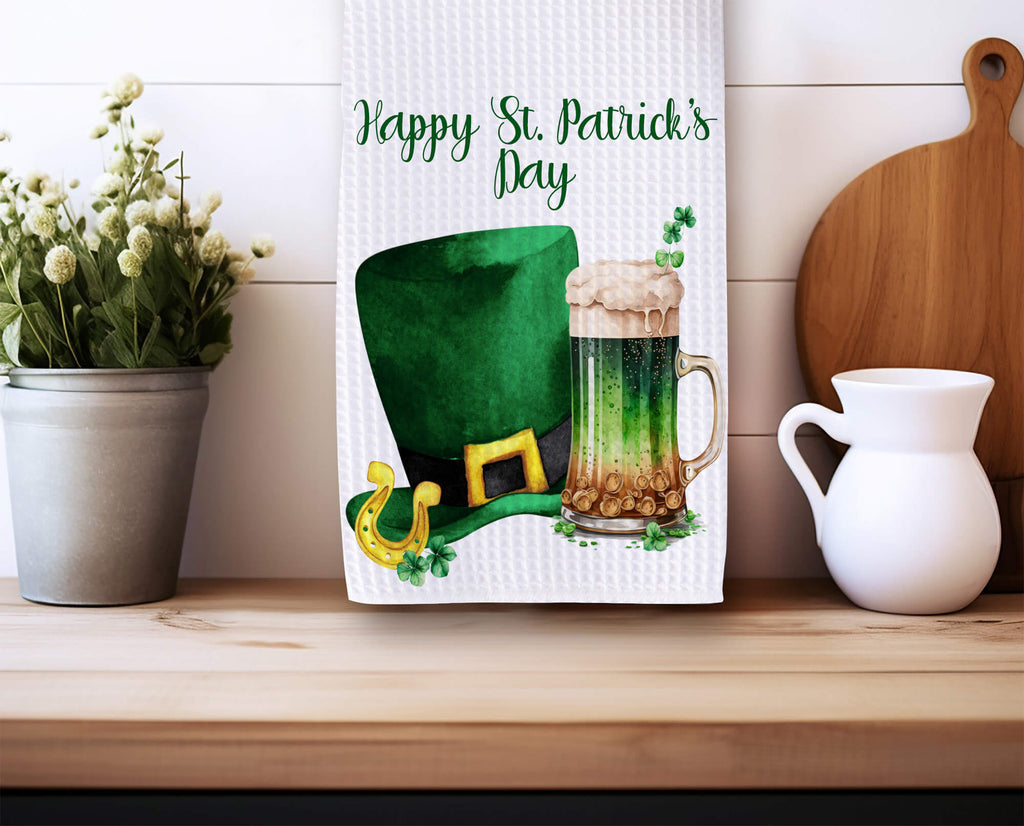 St. Patrick’s Day kitchen towel featuring a green beer mug and leprechaun hat, perfect for festive Irish decor. Soft, absorbent, and machine washable, ideal for farmhouse kitchens, bars, and holiday celebrations