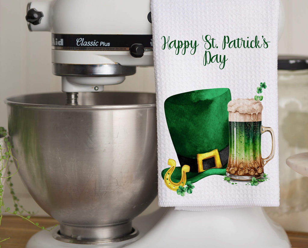 St. Patrick’s Day kitchen towel featuring a green beer mug and leprechaun hat, perfect for festive Irish decor. Soft, absorbent, and machine washable, ideal for farmhouse kitchens, bars, and holiday celebrations - Personalized Kreation