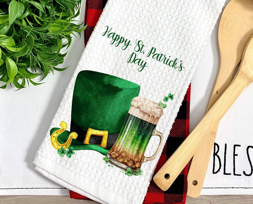 St. Patrick’s Day kitchen towel featuring a green beer mug and leprechaun hat, perfect for festive Irish decor. Soft, absorbent, and machine washable, ideal for farmhouse kitchens, bars, and holiday celebrations - Personalized Kreation