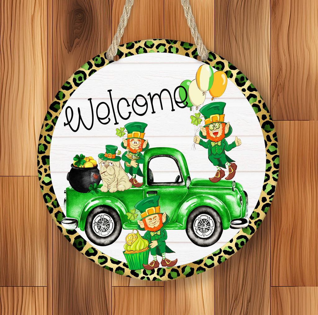 St. Patrick’s Day Welcome Sign featuring a green truck with leprechauns, shamrocks, gold coins, and a lucky cat. Round wooden door hanger with leopard print border, perfect for Irish home decor, front porch, or entryway. Festive holiday decoration for St. Paddy’s Day