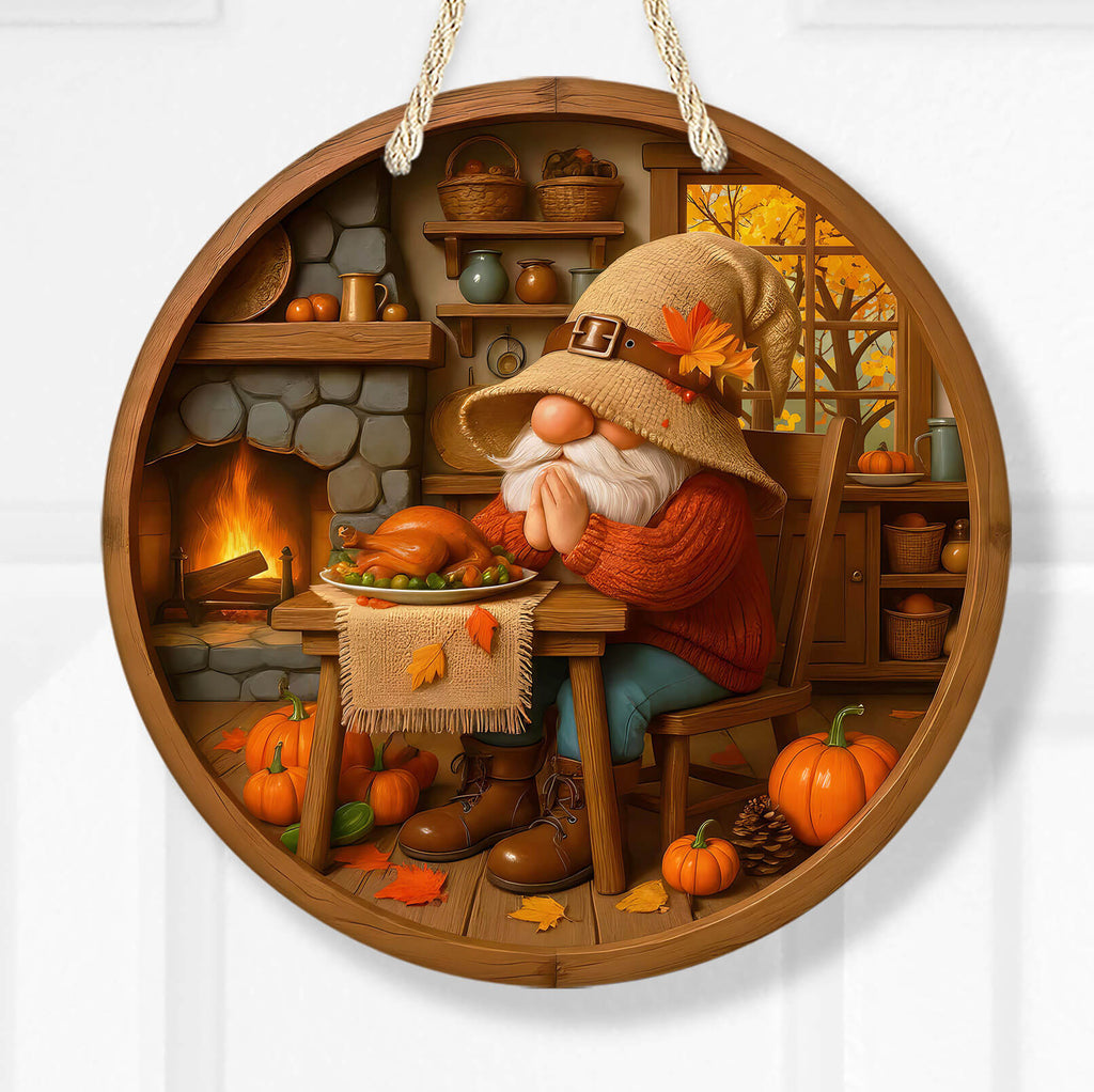 Decorative wall art of a gnome with a harvest theme, sitting at a table with pumpkins and a fireplace.