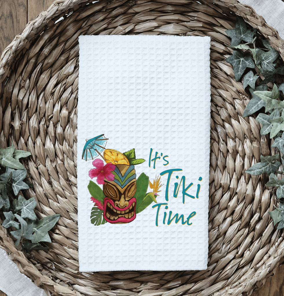 It's Tiki Time kitchen towel featuring a vibrant tiki mask design with tropical flowers and cocktail umbrella, perfect for tiki bar décor, luau parties, and summer kitchen accents - Personalized Kreation